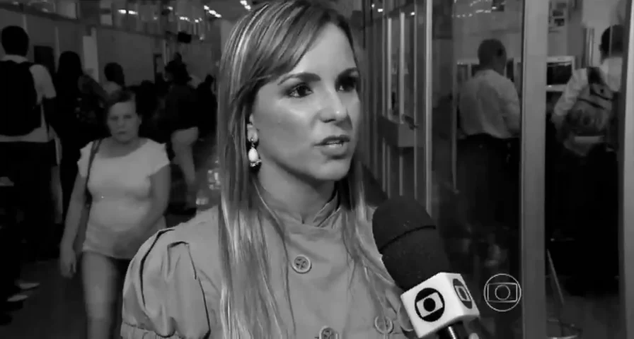 Dra. Cinthya Andrade dando entrevista, diante de um microfone da TV Globo